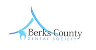 The image displays a logo with text that reads  Berk s County Dental Society.  It features an abstract design resembling a stylized tree or mountain range, with the name of the organization in capital letters.