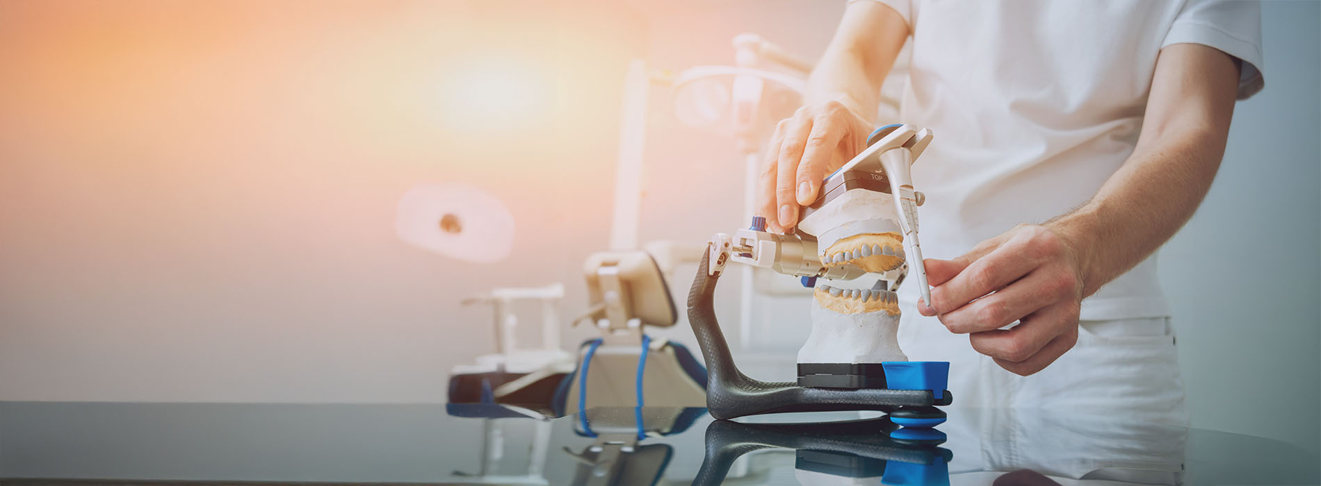 The image depicts a person wearing a white lab coat standing next to a table with various pieces of scientific equipment, suggesting a laboratory setting.